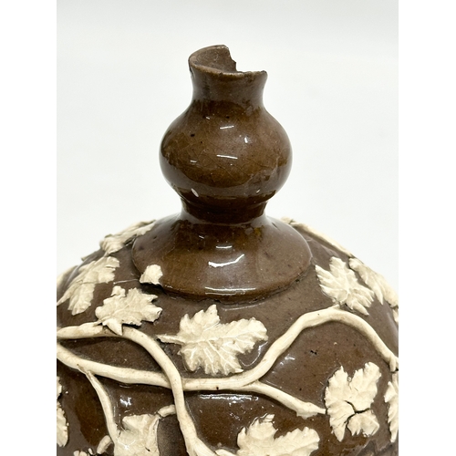 37 - An 18th Century glazed stoneware bottle, with moulded relief vines and leaves. 11x18cm