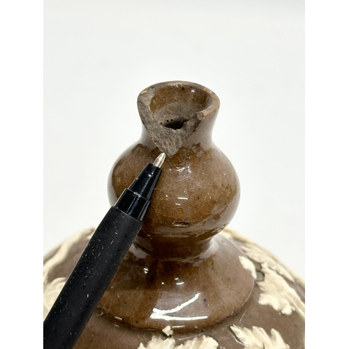 37 - An 18th Century glazed stoneware bottle, with moulded relief vines and leaves. 11x18cm