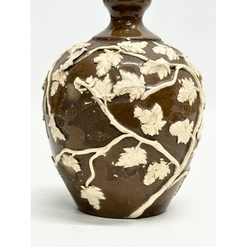 37 - An 18th Century glazed stoneware bottle, with moulded relief vines and leaves. 11x18cm