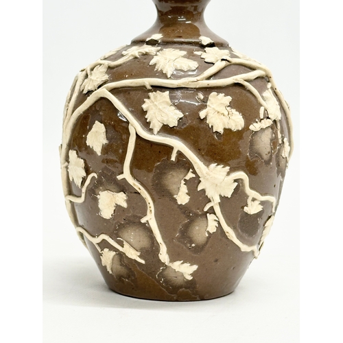 37 - An 18th Century glazed stoneware bottle, with moulded relief vines and leaves. 11x18cm