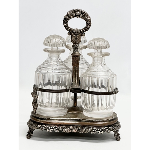 86 - Dan Holy, Parker & Co. An Early 19th Century George III silver plated decanter stand with 3 decanter... 