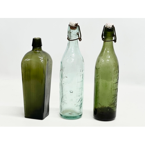 444 - 3 Early 20th Century glass bottles. 2 by Fowler of Belfast and a green gin bottle. 29cm