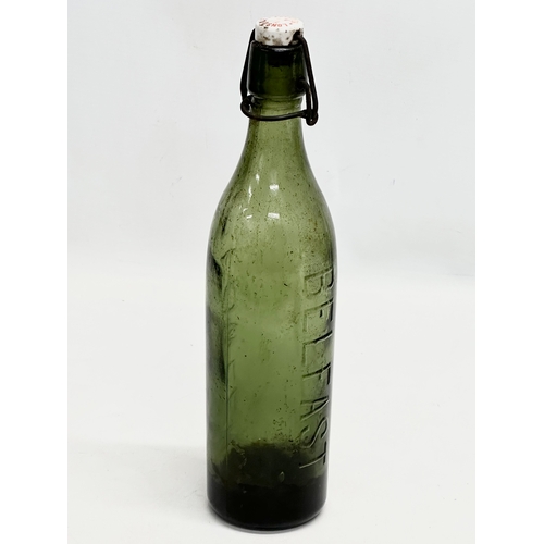 444 - 3 Early 20th Century glass bottles. 2 by Fowler of Belfast and a green gin bottle. 29cm