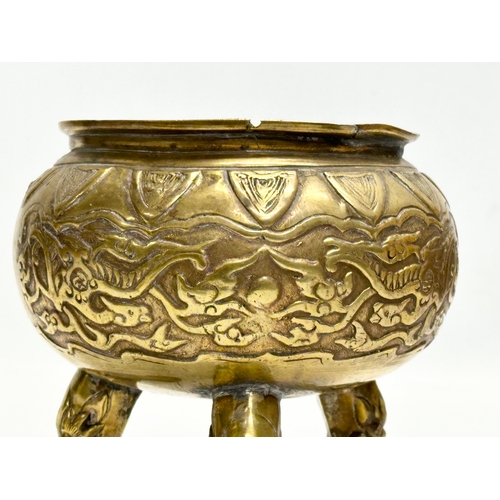 34 - A 19th Century Chinese brass tripod censer/incense burner. With engraved dragons and serpents. Raise... 