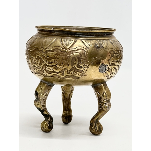 34 - A 19th Century Chinese brass tripod censer/incense burner. With engraved dragons and serpents. Raise... 