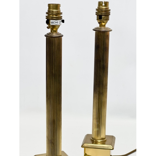 303 - A pair of brass table lamps with reeded columns. 42cm.