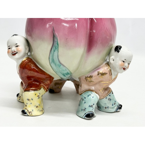 343 - A Chinese ceramic figure of 3 children and peach. 18x25cm