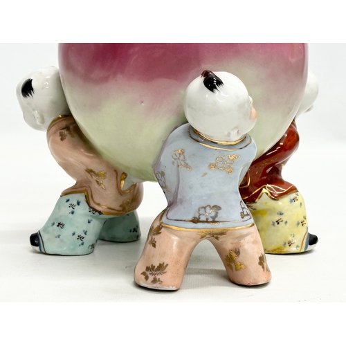 343 - A Chinese ceramic figure of 3 children and peach. 18x25cm