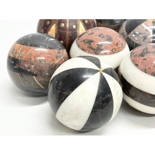 39 - A collection of Early 20th Century French marble balls. Including a larger leather and brass bound, ... 