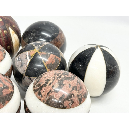 39 - A collection of Early 20th Century French marble balls. Including a larger leather and brass bound, ... 