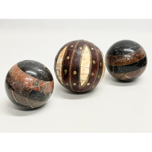 39 - A collection of Early 20th Century French marble balls. Including a larger leather and brass bound, ... 