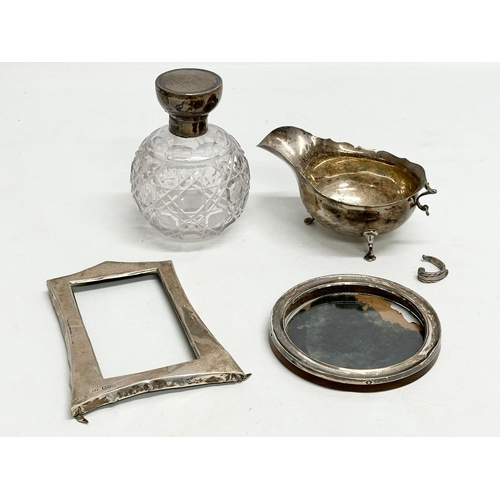 473 - A quantity of silver. Gravy boat 105.98 grams. Art Nouveau style picture frame 25.24 grams. A perfum... 