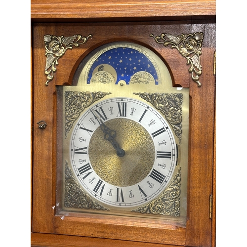 379 - A large Georgian style wall clock with brass moon dial face. 3 weights and pendulum. 44x26x126cm.