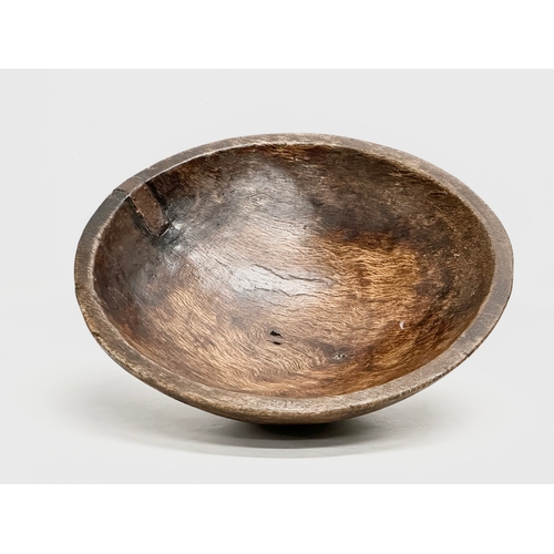 51 - A Late 18th/Early 19th Century George III oak bowl. With hand forged iron repair. Circa 1760-1810. 3... 