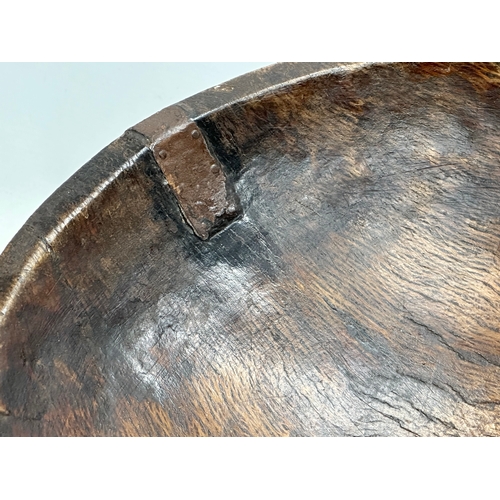 51 - A Late 18th/Early 19th Century George III oak bowl. With hand forged iron repair. Circa 1760-1810. 3... 