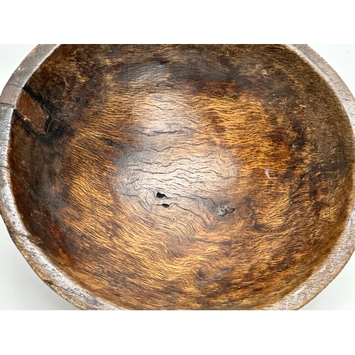 51 - A Late 18th/Early 19th Century George III oak bowl. With hand forged iron repair. Circa 1760-1810. 3... 