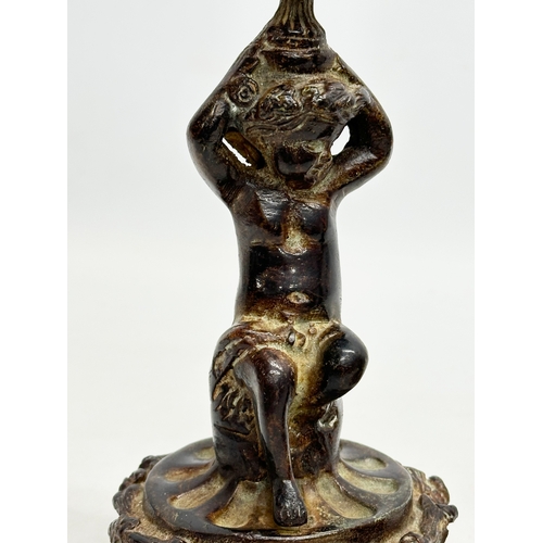 53 - A pair of Early 19th Century iron cherub candlesticks. 20cm