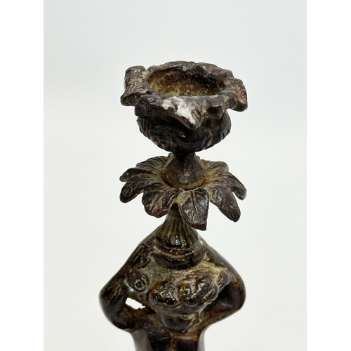 53 - A pair of Early 19th Century iron cherub candlesticks. 20cm