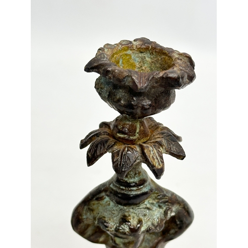 53 - A pair of Early 19th Century iron cherub candlesticks. 20cm