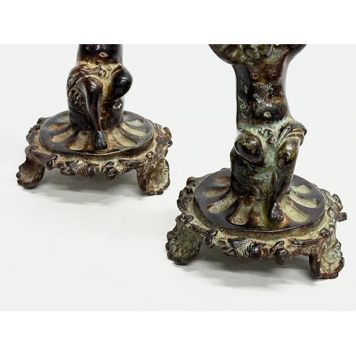 53 - A pair of Early 19th Century iron cherub candlesticks. 20cm