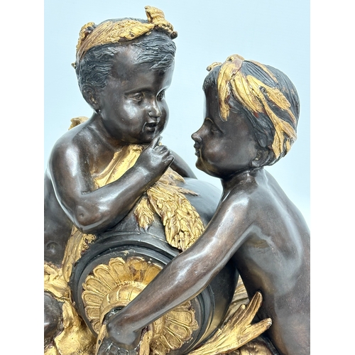 19 - A large signed Late 19th/Early 20th Century bronze sitting cherubs. Holding a gilded urn with rosett... 