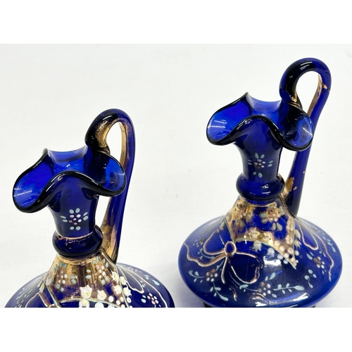 218 - A pair of small Late 19th Century Bristol Blue glass ewers. 10.5cm