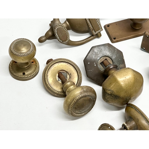 245 - A collection of Victorian brass door handles and a later door knocker.