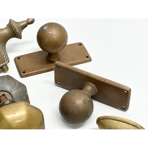 245 - A collection of Victorian brass door handles and a later door knocker.