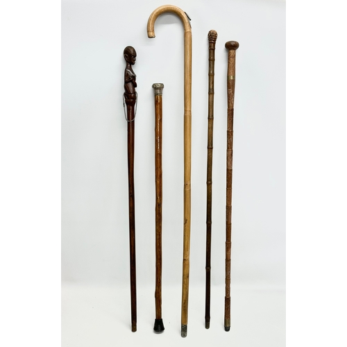 247 - A collection of vintage walking sticks. Induding a horse measuring stick.