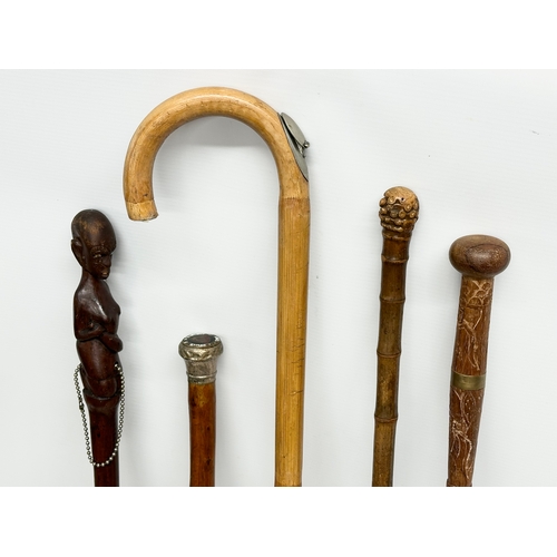 247 - A collection of vintage walking sticks. Induding a horse measuring stick.