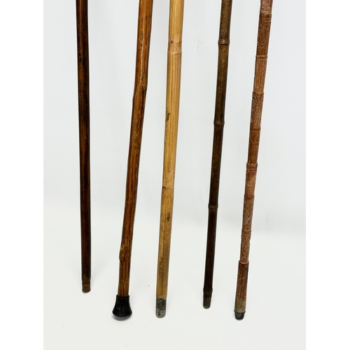 247 - A collection of vintage walking sticks. Induding a horse measuring stick.