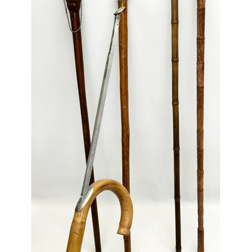 247 - A collection of vintage walking sticks. Induding a horse measuring stick.