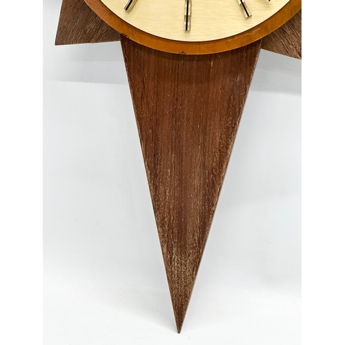 190 - A Mid Century teak sunburst clock. Acctim. 40x64cm