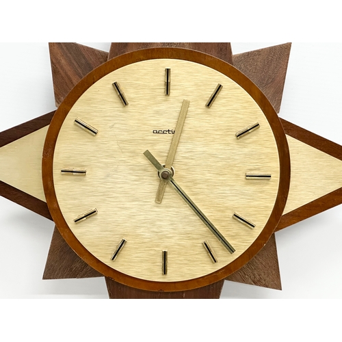 190 - A Mid Century teak sunburst clock. Acctim. 40x64cm