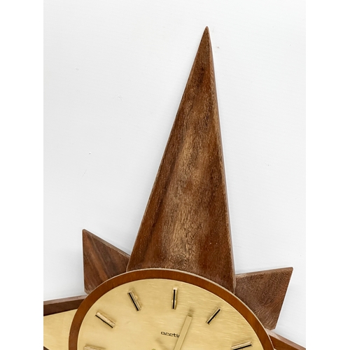 190 - A Mid Century teak sunburst clock. Acctim. 40x64cm