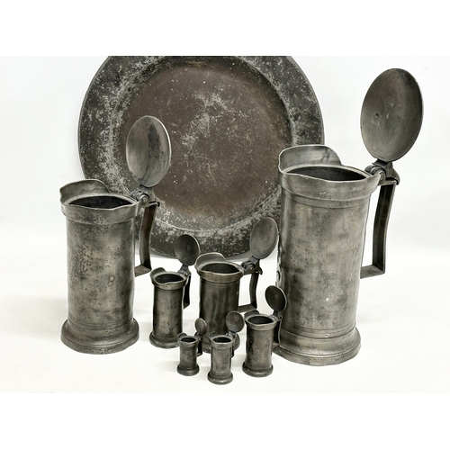 279 - A collection of 19th Century French pewter. 7 pewter measures/tankards and a pewter tray. Largest me... 