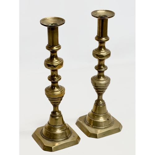 634 - Two pairs of Victorian brass candlesticks. 29cm. 27cm.