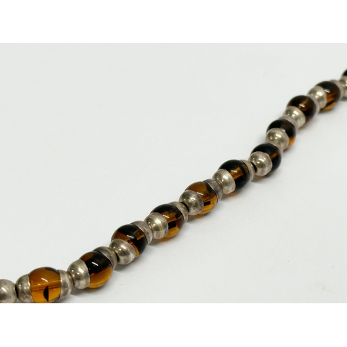 655 - A large silver and amber glass necklace.