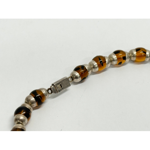 655 - A large silver and amber glass necklace.