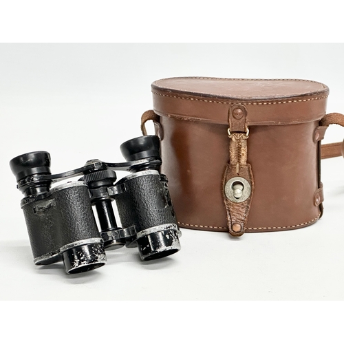 671 - A pair of Early/Mid 20th Century binoculars with original leather case.