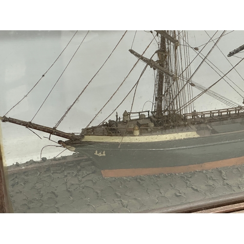 208 - A large 19th Century model ship on display case. 73x30.5x53cm.