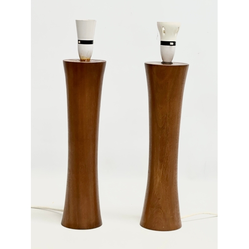 188A - A pair of tall 1970’s Mid Century teak table lamps. Bases measure 44cm. 58cm with shades.