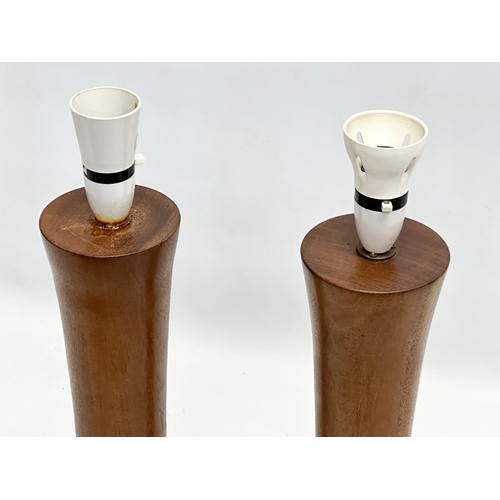 188A - A pair of tall 1970’s Mid Century teak table lamps. Bases measure 44cm. 58cm with shades.