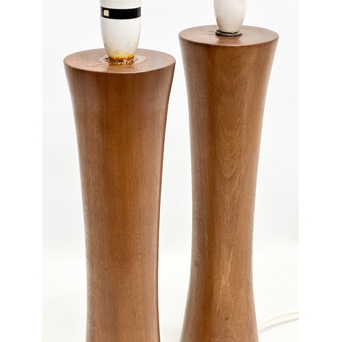 188A - A pair of tall 1970’s Mid Century teak table lamps. Bases measure 44cm. 58cm with shades.