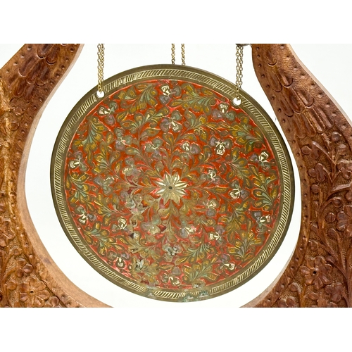 741 - A vintage Indian engraved brass gong with carved teak frame. 25x28cm