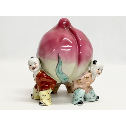 689 - A Chinese ceramic figure of 3 children and peach. 18x25cm