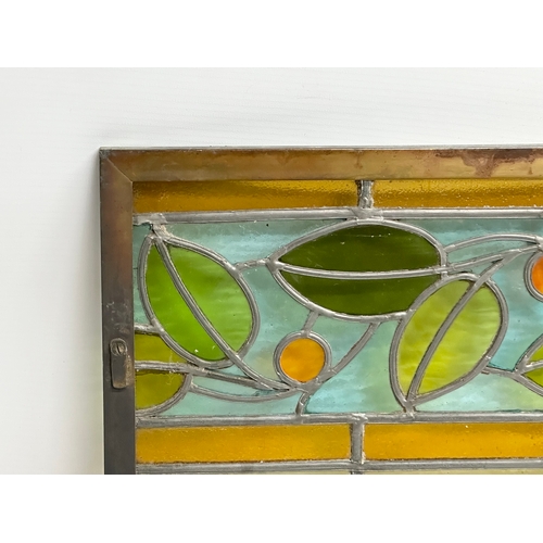 55A - A pair of large bronzed framed Early 20th Century stained glass panels. 111.5x40cm