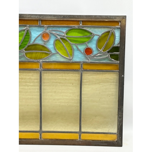 55B - A pair of large bronzed framed Early 20th Century stained glass panels. 111.5x40cm