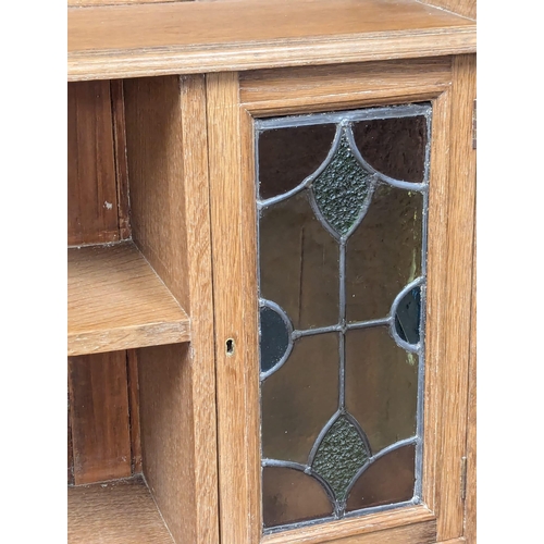 1062 - A Late 19th Century / Early 20th Century oak Arts & Crafts bookcase with two lead glass doors. Circa... 