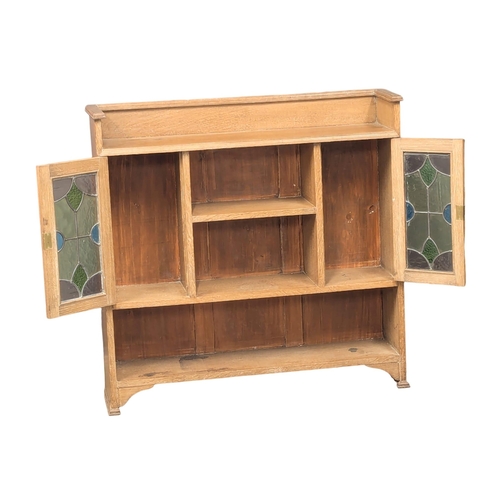 1062 - A Late 19th Century / Early 20th Century oak Arts & Crafts bookcase with two lead glass doors. Circa... 